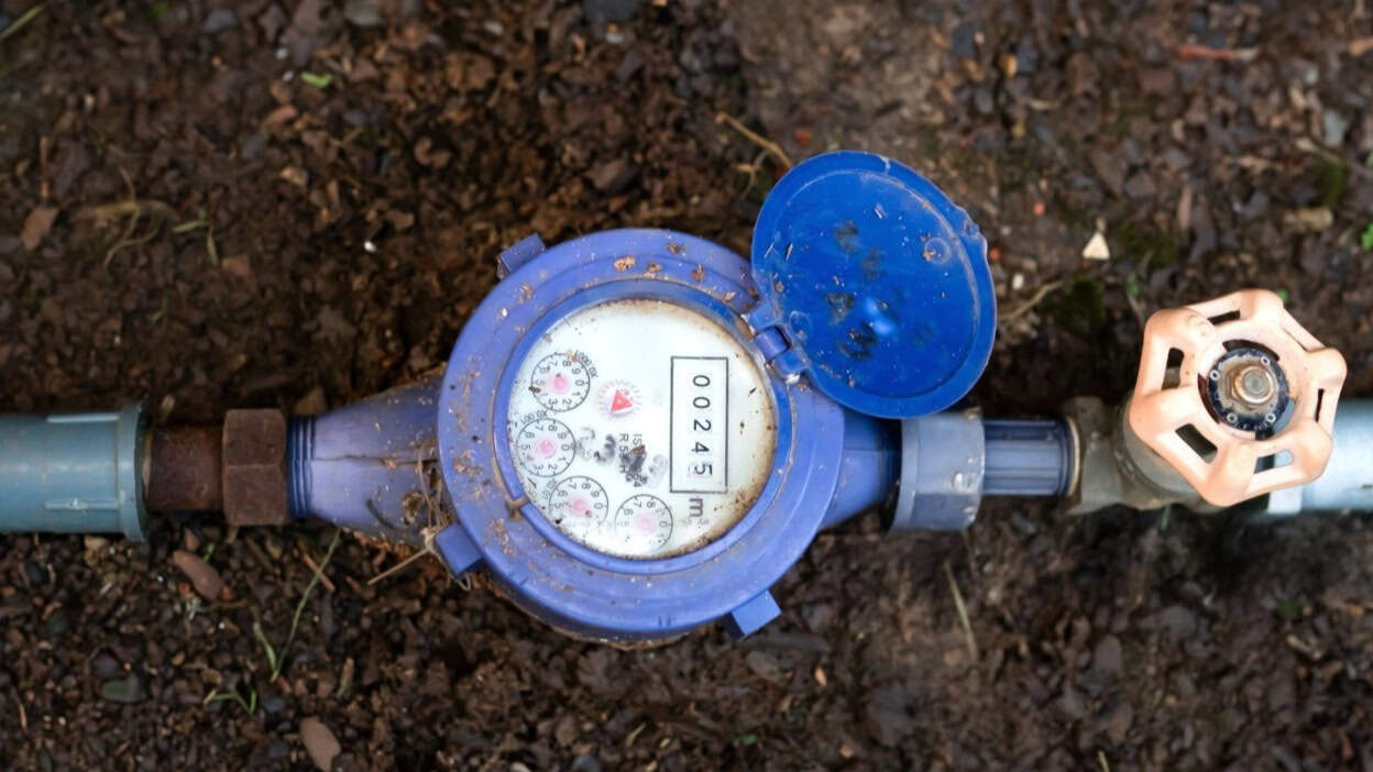 Homeowner in London checking water meter for hidden leak detection